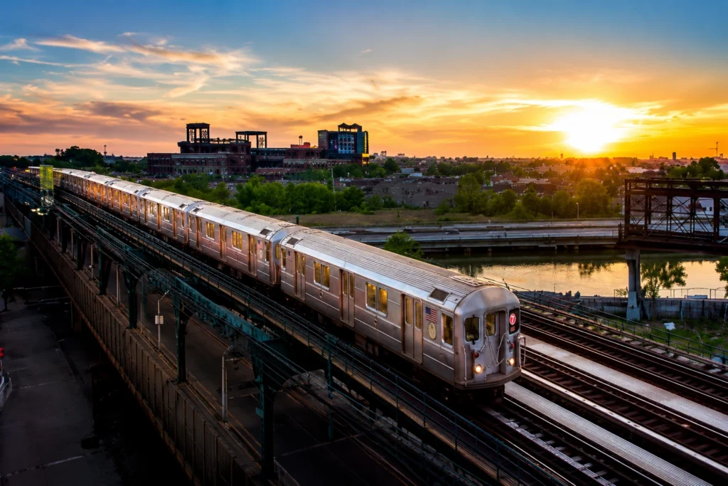 Train on elevated tracks during sunset.