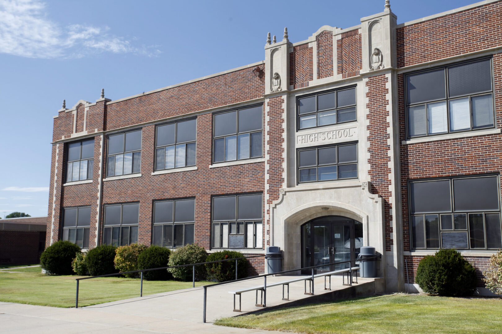 Brick high school building with large windows.