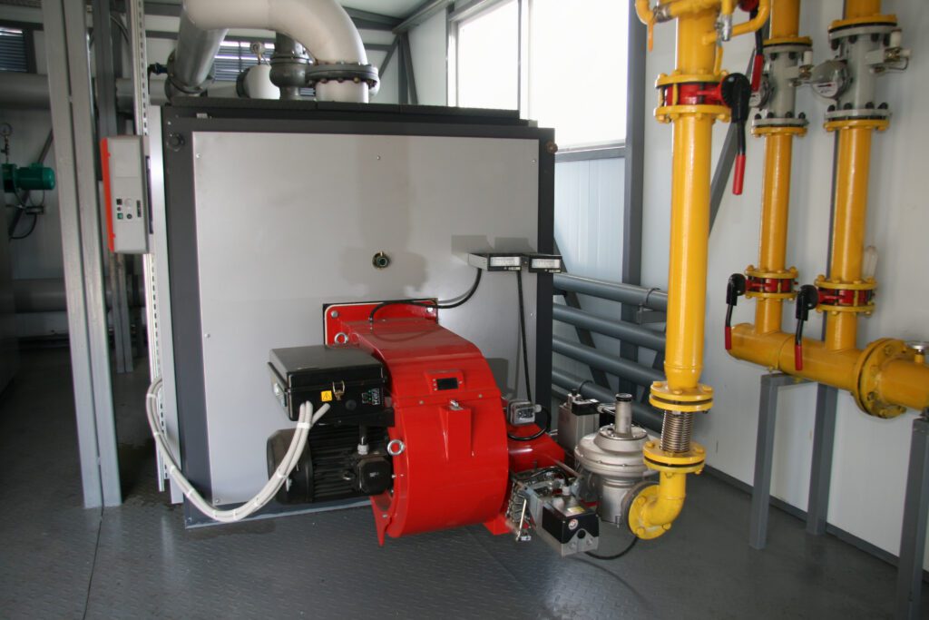 Industrial boiler room with pipes and machinery.
