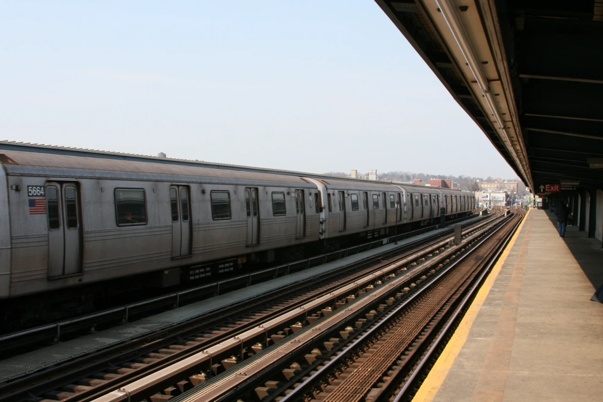Subway train at outdoor station platform.