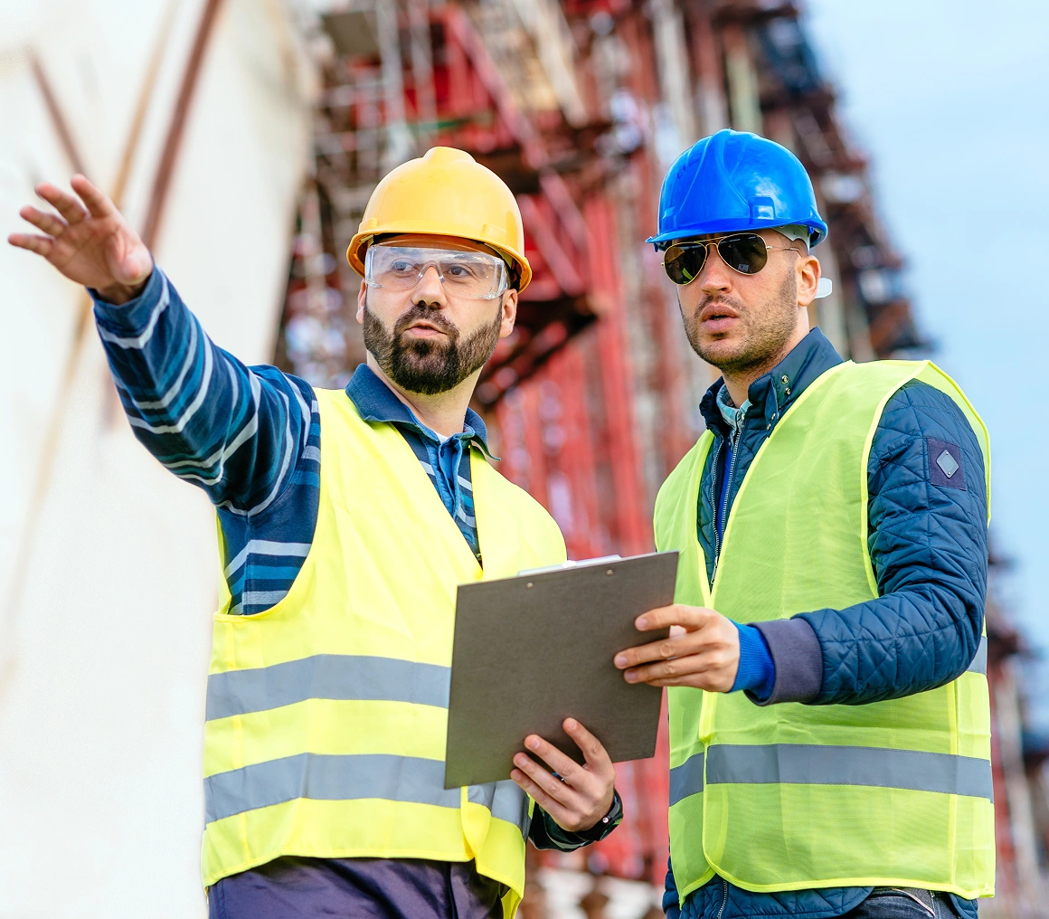 Two construction workers discussing site plans.