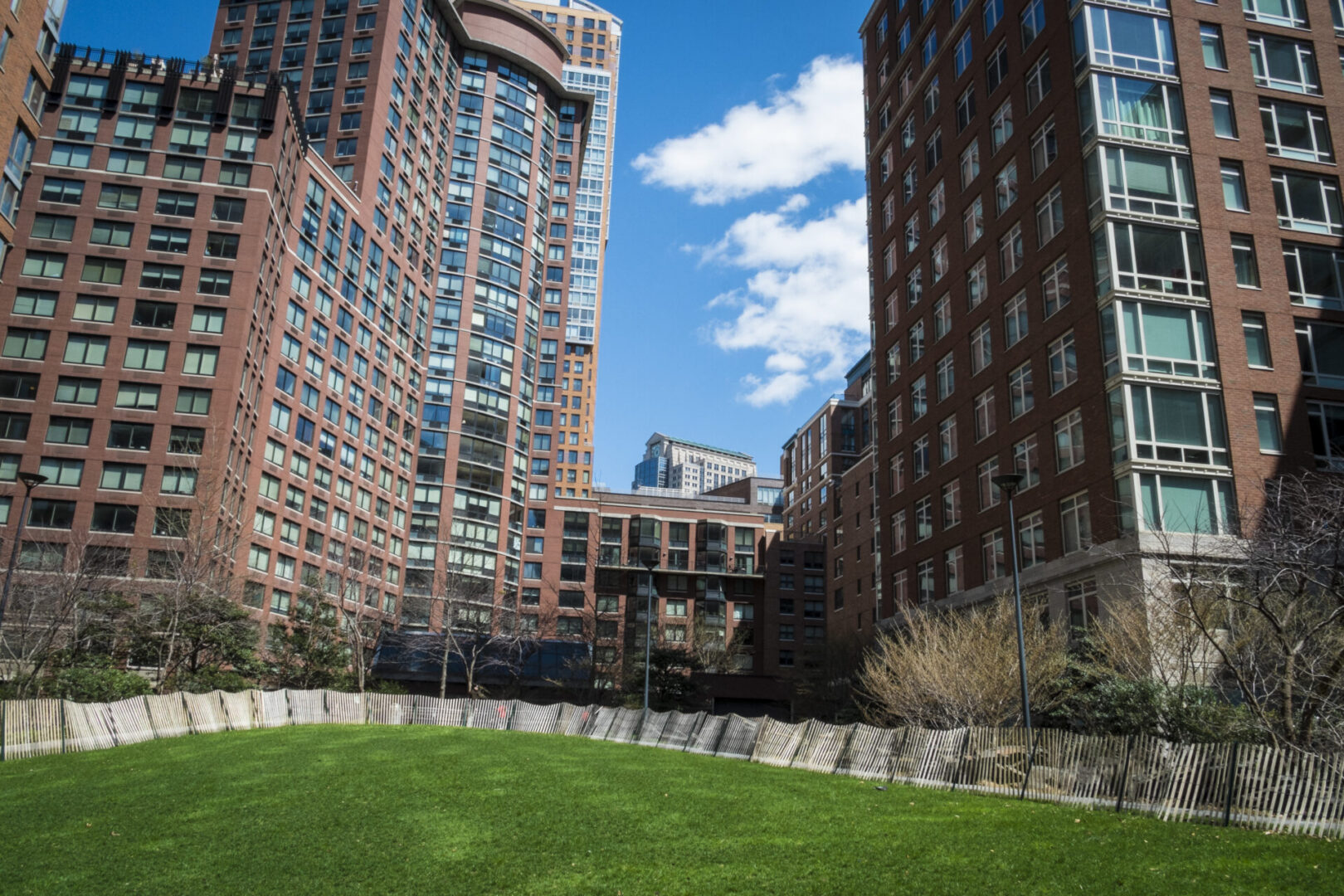 Urban park surrounded by tall buildings.