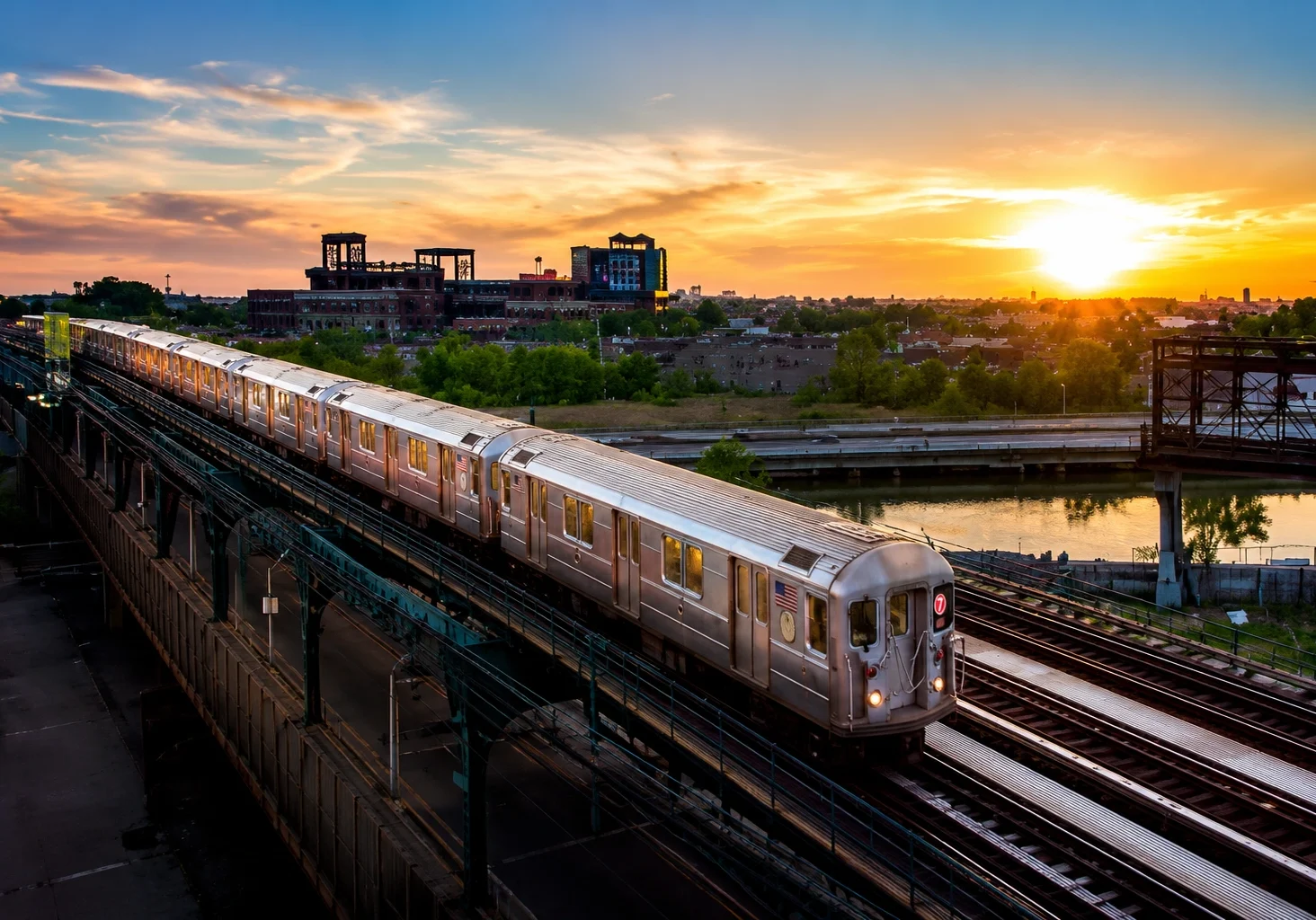 Train on elevated tracks during sunset.