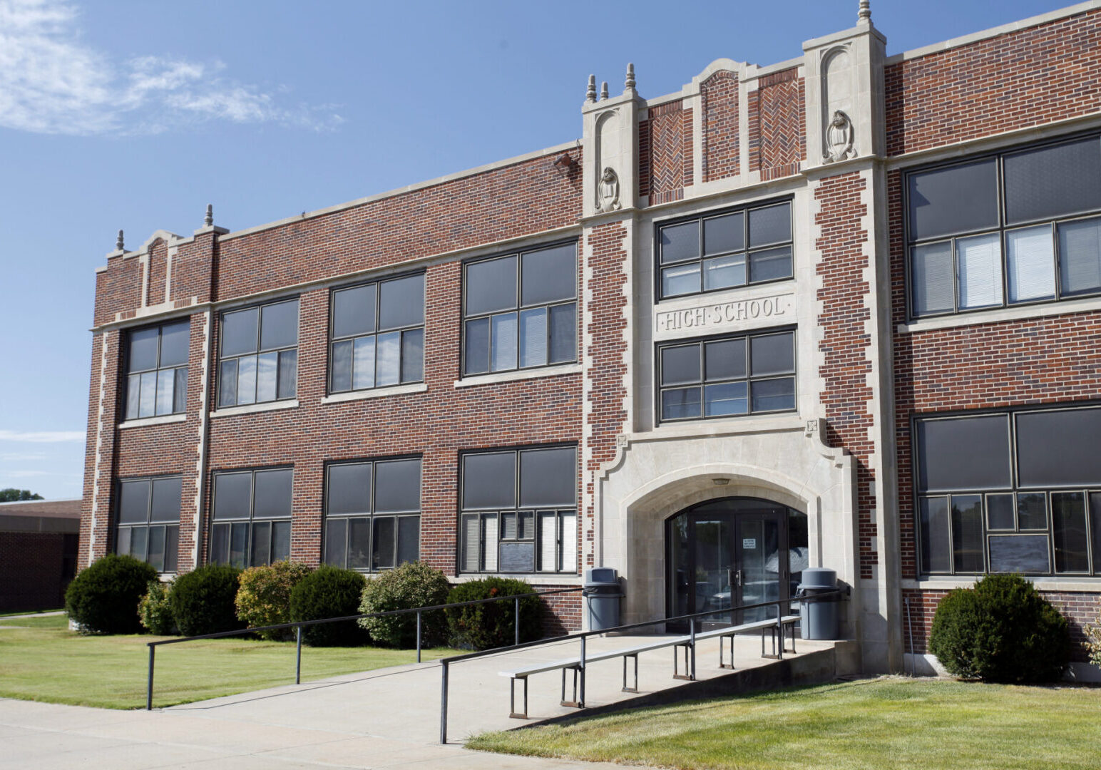 Brick high school building with large windows.