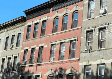 Historic urban apartment buildings under blue sky.