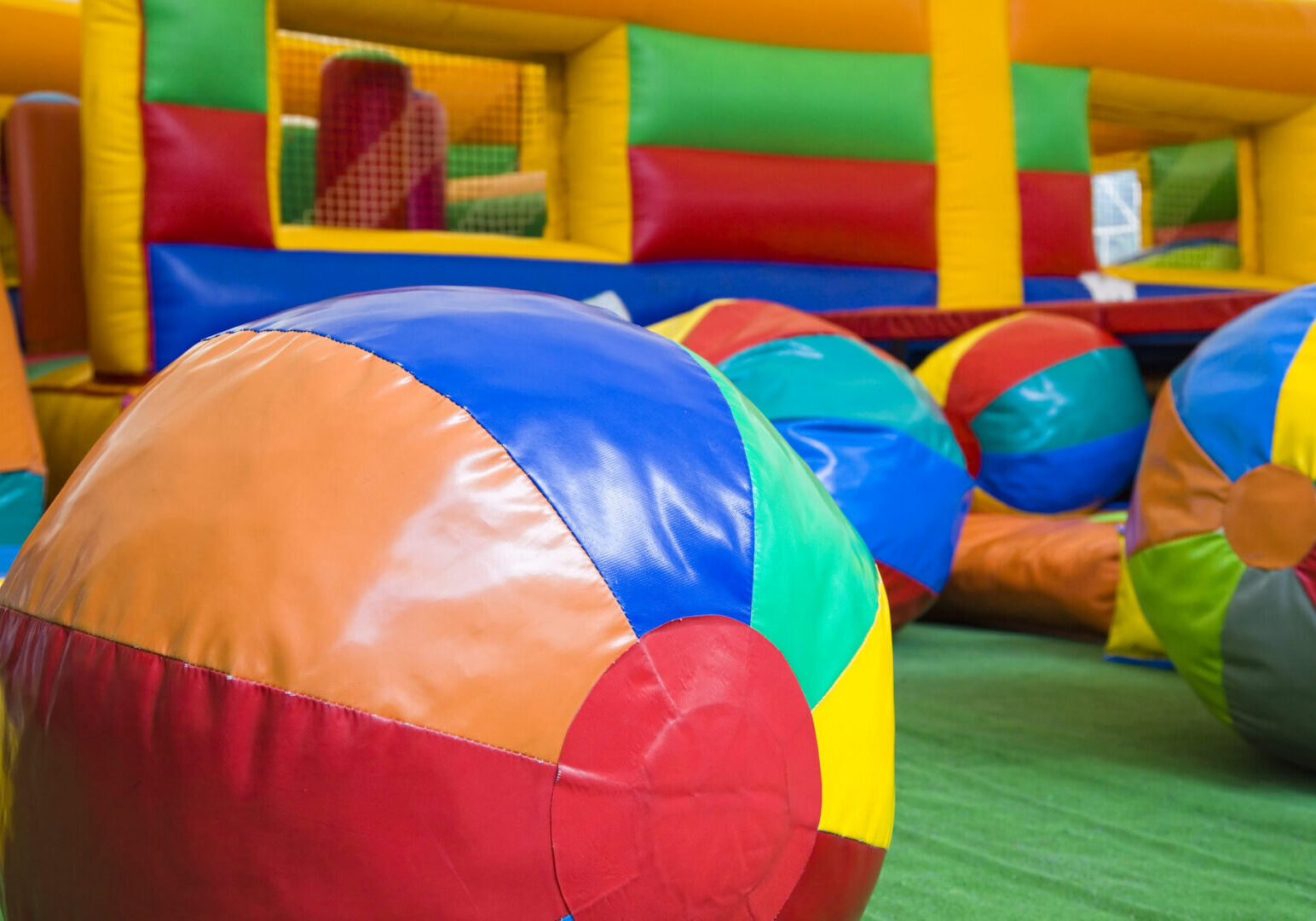 Colorful beach balls in inflatable play area.