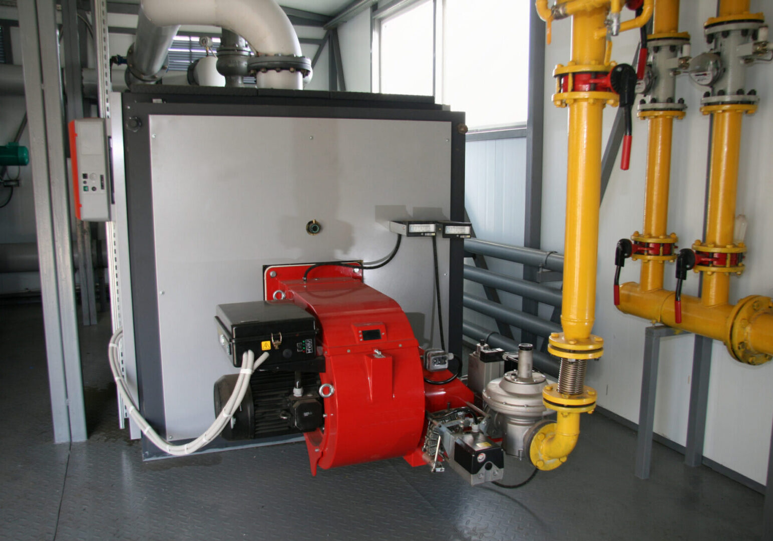 Industrial boiler room with pipes and machinery.