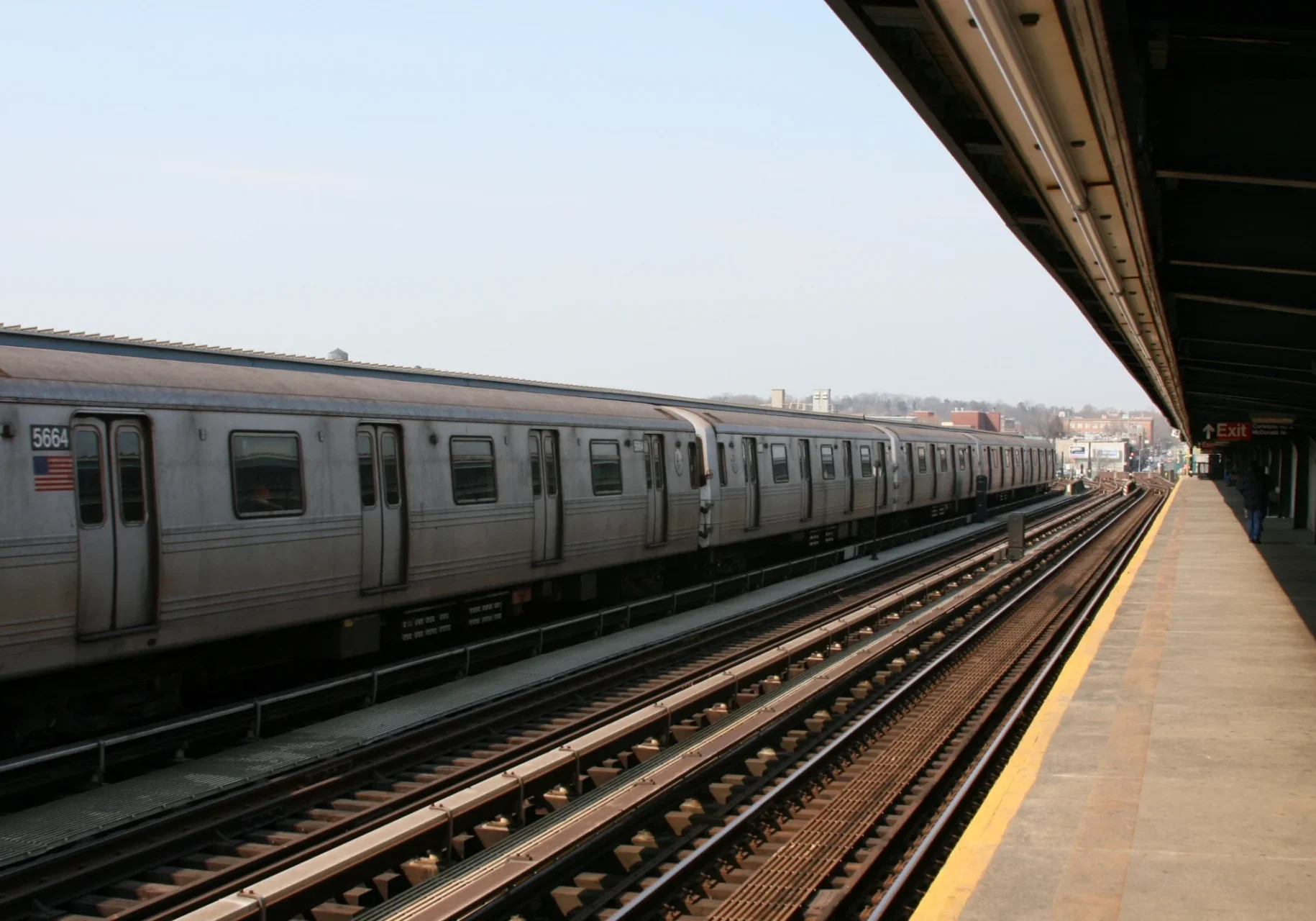 Subway train at outdoor station platform.