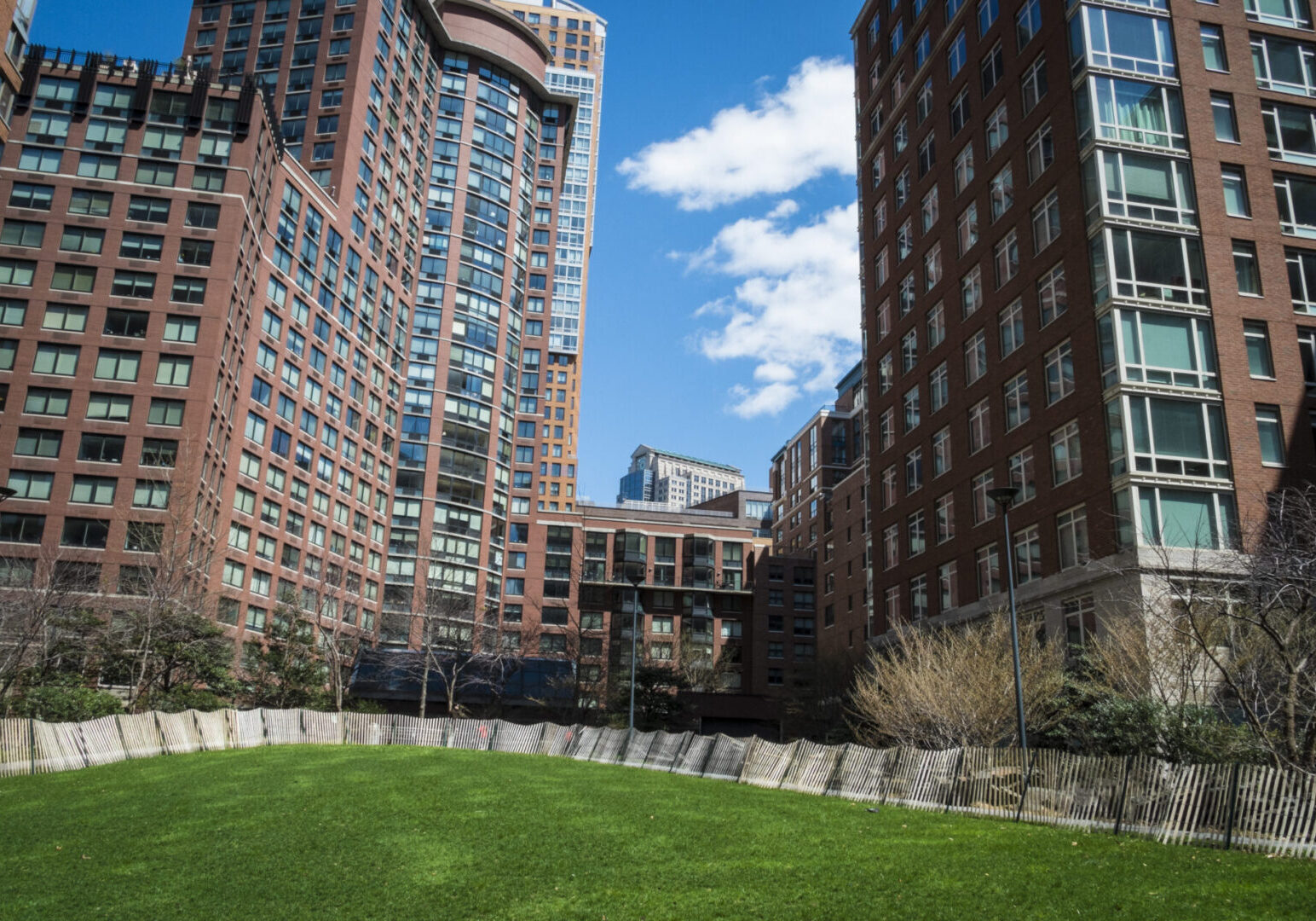 Urban park surrounded by tall buildings.